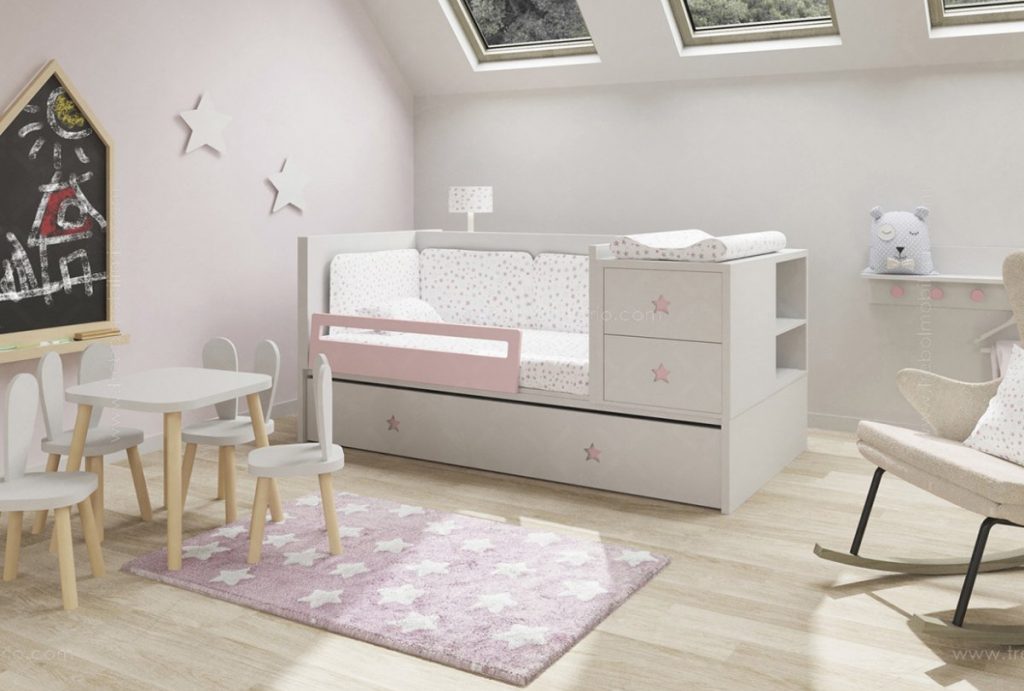 Una acogedora habitación infantil con una combinación de colores blanco y rosa. Cuenta con una cama con ropa de cama con estampado de estrellas y una barandilla lateral de seguridad, una mesa pequeña con sillas, una mecedora y una alfombra con estampado de estrellas. También se ve una pizarra con dibujos y decoraciones de estrellas en las paredes.